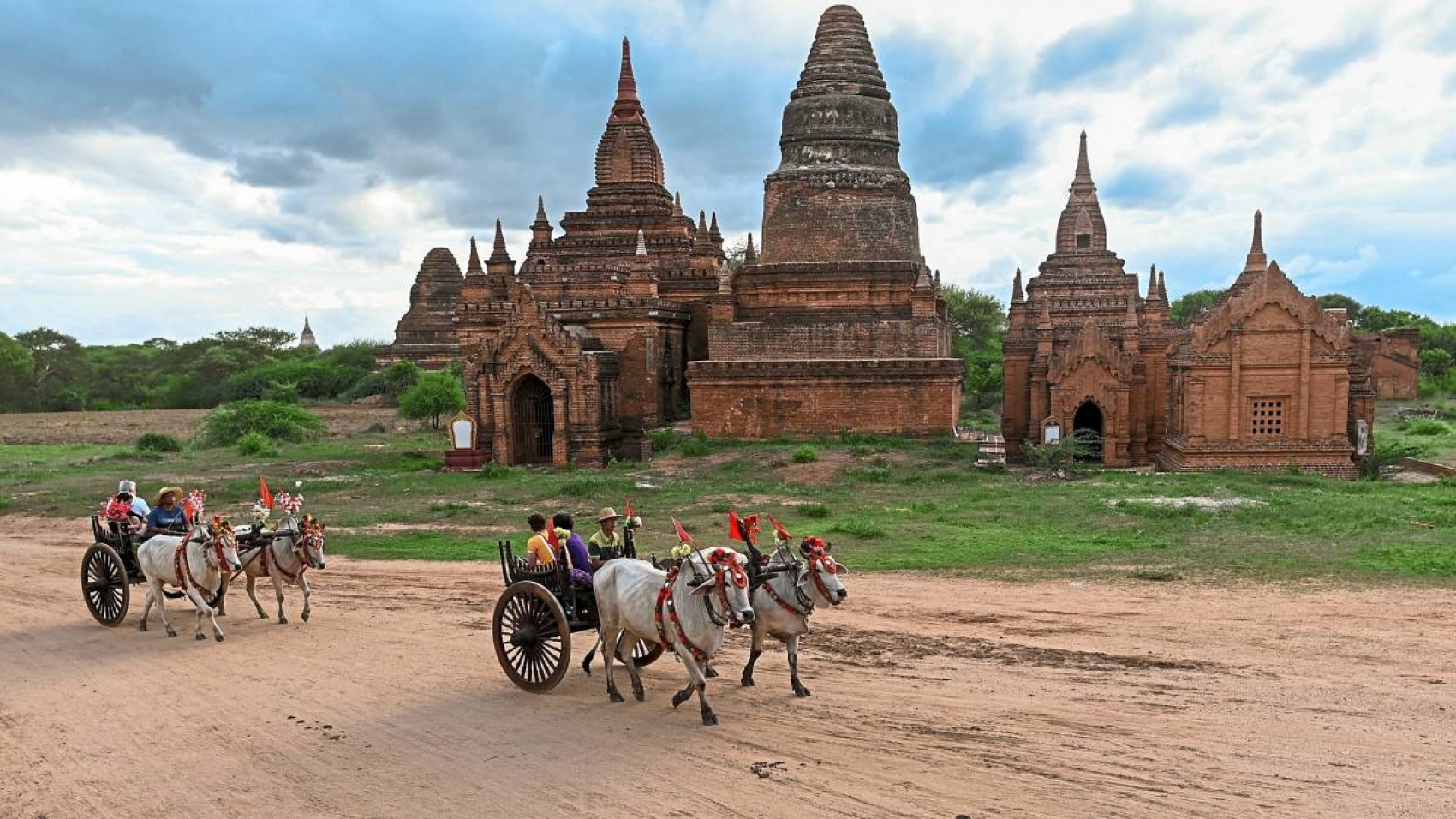<p>Tourists riding bull carts travel along a road across an ancient Buddhist temple in Bagan on July 5, 2019. (Photo by Ye Aung THU / AFP)</p>